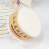 A ball of white mohair blended yarn is shown next to a gold wire hanger.