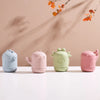 Four soft silicone animal bath toys in light blue, pink, green, and pink are displayed on a white surface.