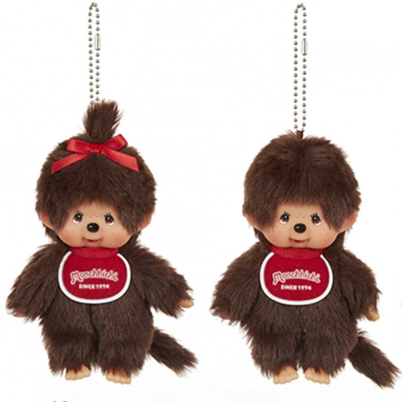 A brown Monchhichi plush toy with a red bow, shown as a keychain.