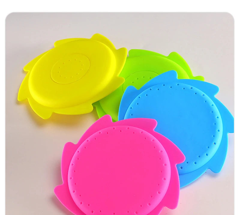 A collection of brightly colored silicone splash flying rings in yellow, green, and blue, used for water play.