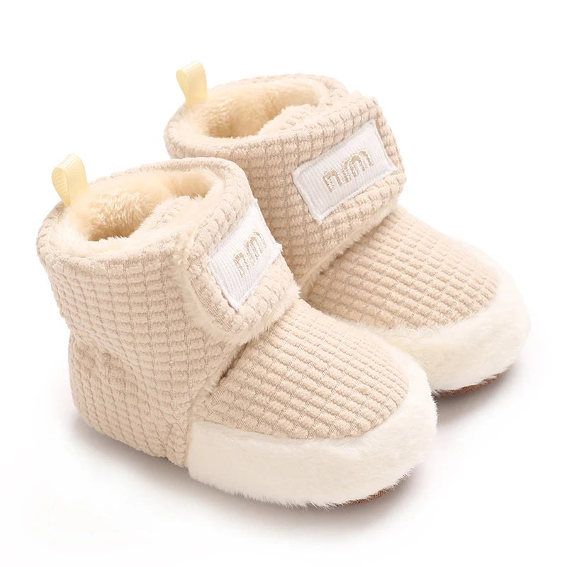 A pair of beige baby winter cartoon boots with soft faux fur lining and non-slip soles.