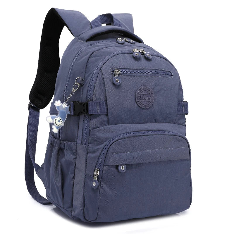 Sac de voyage bleu marine et durable avec sangles noires et un charm argenté.