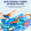 A hand is using a soft fabric sponge filling tool to fill colorful plastic fish shapes for a toddler learning game.
