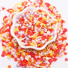 A pile of colorful polymer clay sprinkles mix featuring red, orange, pink, and yellow heart shapes and pearl accents.