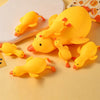 A collection of yellow duck squishy stress relief toys arranged on a white plate.