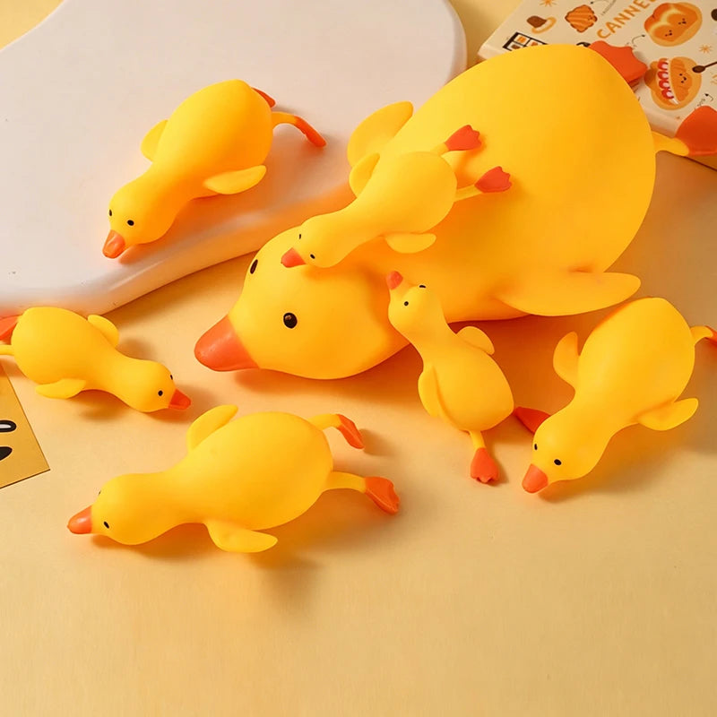 A collection of yellow duck squishy stress relief toys arranged on a white plate.