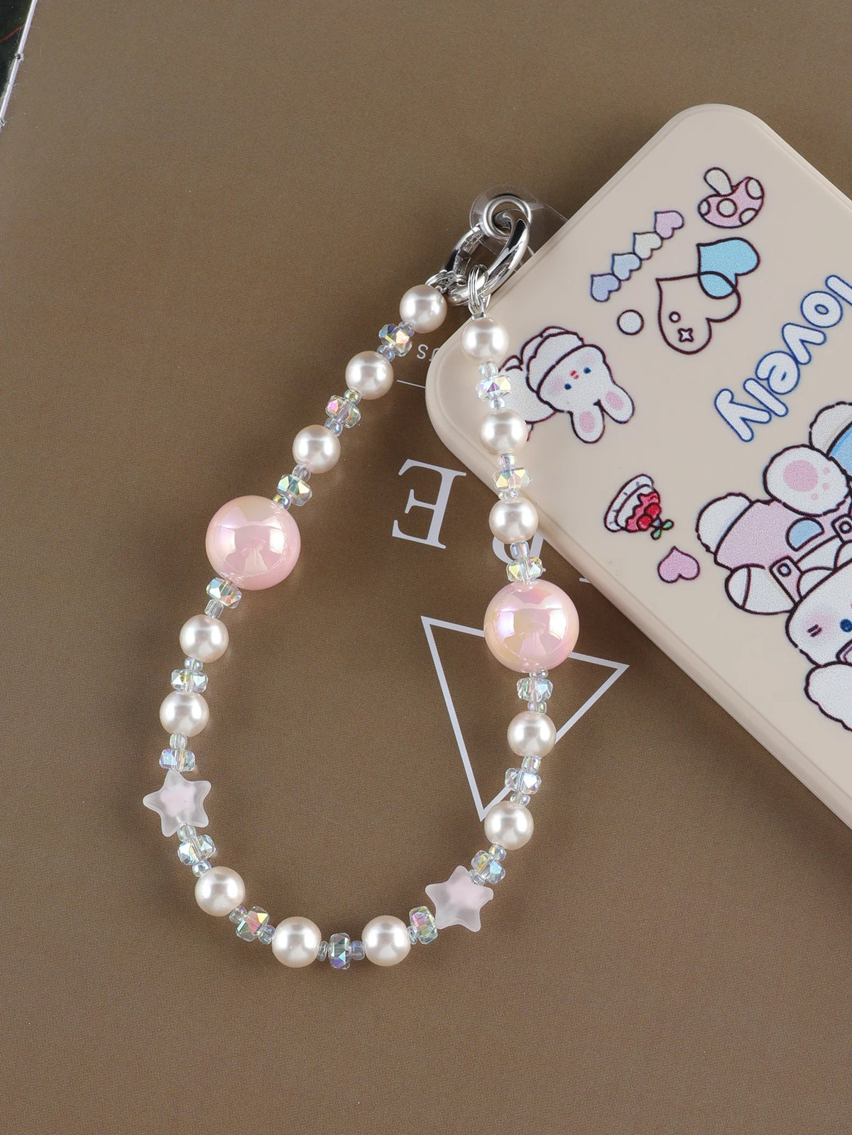 A necklace featuring pink and clear pearl crystals and a star charm attached to a bag clip.