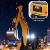A yellow mini RC excavator is shown operating in a dark, outdoor setting with bright lights.