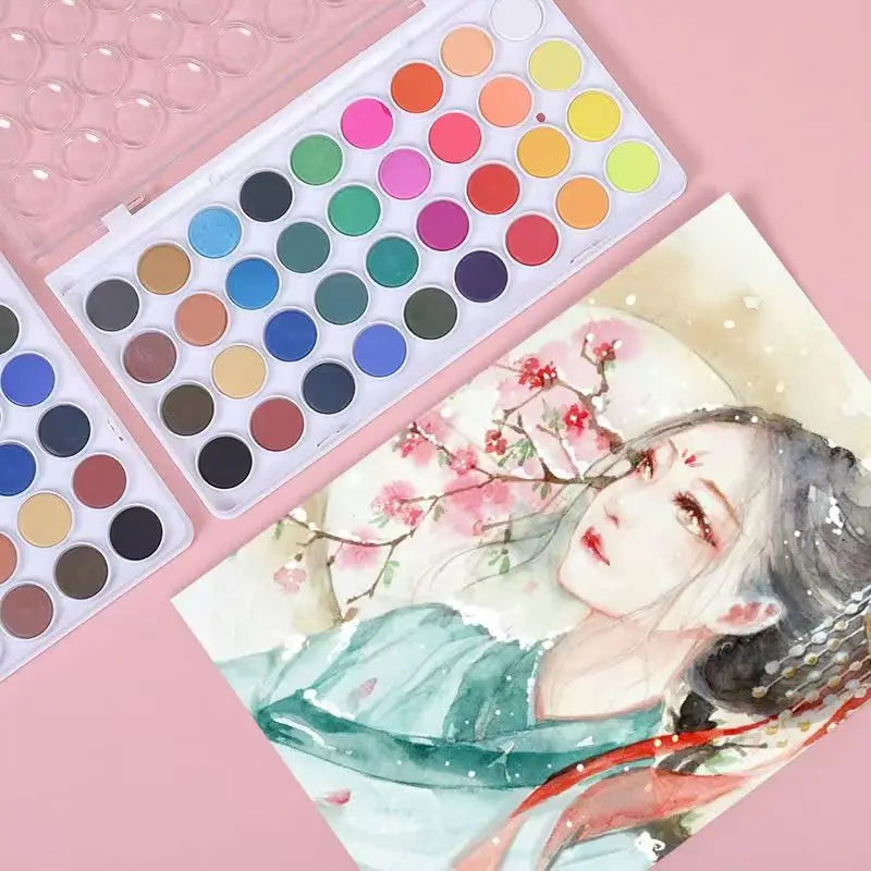 A portable watercolor paint set featuring a palette of various colored paints and an illustration of a woman with pink flower