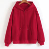 A maroon oversized zip-up hoodie with a front pocket is displayed on a hanger.