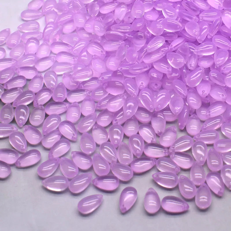Pile of translucent purple water drop glass beads for jewelry making