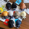 A collection of black, orange, and beige anime character plushie pendants and charms displayed on a white background.