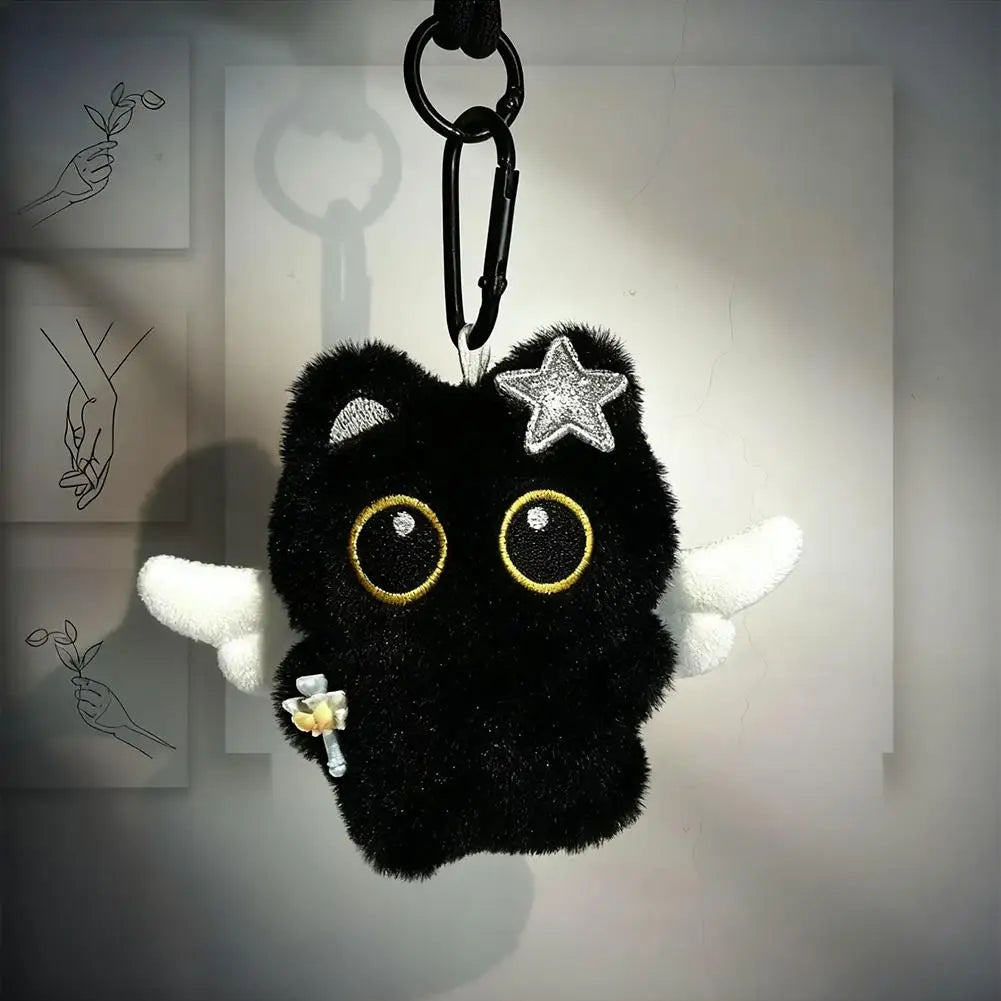 A black plush cat with large yellow eyes and a silver star charm hanging from a metal keyring.