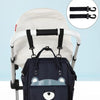 A navy blue waterproof diaper backpack with a changing mat and stroller hanging straps is shown on a white stroller.