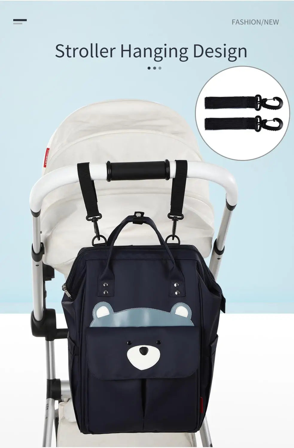 A navy blue waterproof diaper backpack with a changing mat and stroller hanging straps is shown on a white stroller.