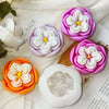 A collection of silicone molds shaped like rose flowers in various shades of purple, pink, and white for candle and soap maki