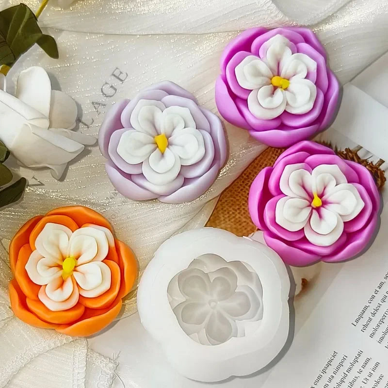 A collection of silicone molds shaped like rose flowers in various shades of purple, pink, and white for candle and soap maki