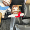 A plush toy depicting a man with a beard and brown hair, wearing a white shirt and blue cloth, is shown in a black box.