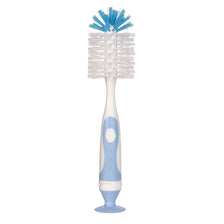 A white baby bottle cleaning brush with blue bristles and a suction stand.
