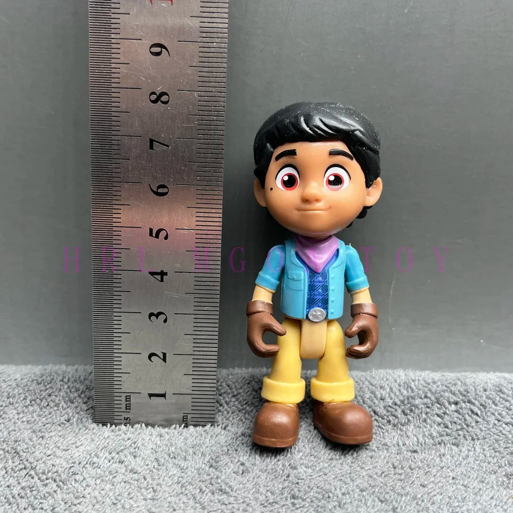 A playful cartoon PVC figurine of a boy with dark hair and large eyes, dressed in blue and yellow clothing.
