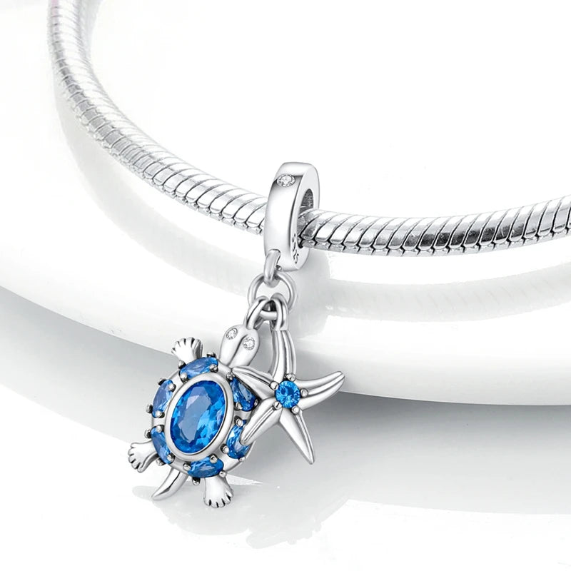 Sterling silver charm pendant set featuring a starfish, sea turtle, and whale shark against a white background