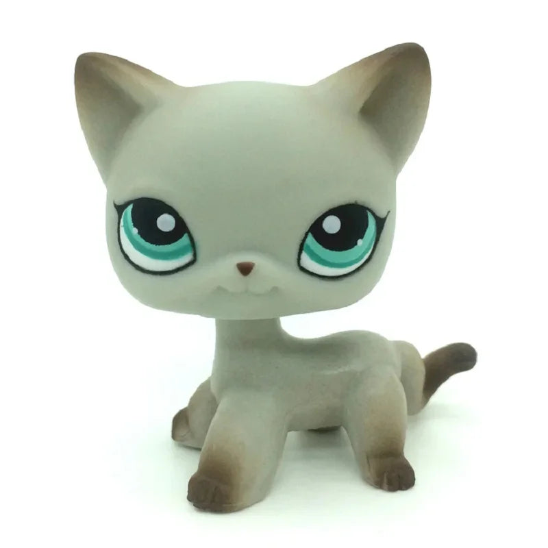 A small, gray and white Littlest Pet Shop style standing dog figure with large green eyes.