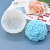 A light blue silicone mold shaped like a peony flower is shown next to a pink rose and a book.