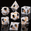 A set of milk white resin dice featuring a black kitten design, displayed on a reflective surface.
