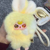 A fluffy yellow bunny collectible with pink facial features and a gold-colored tag.