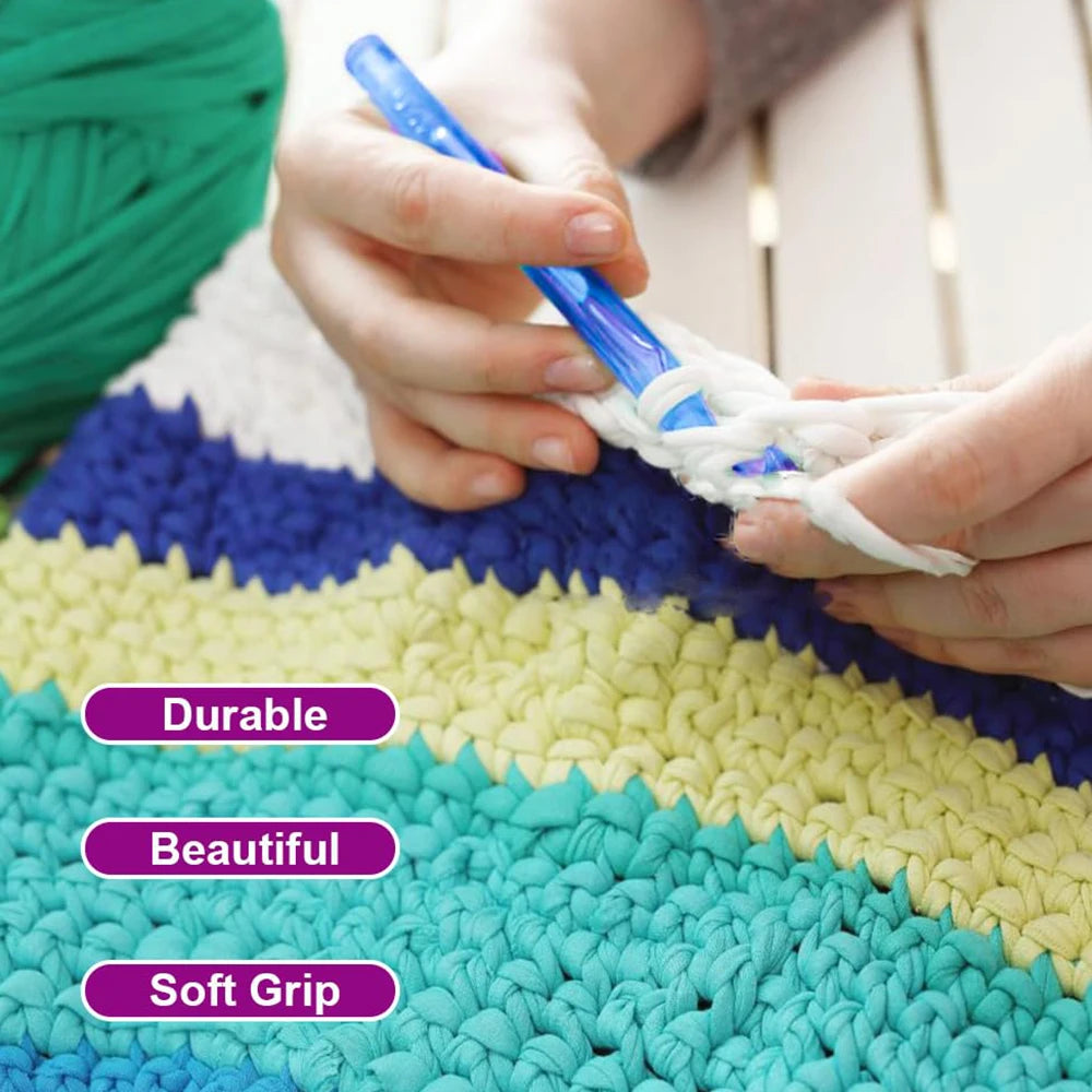 Hands are using a blue crochet hook to work with light-colored yarn on a textured mat.
