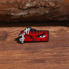 A red enamel lapel pin featuring a fierce, angry face design from Berserk