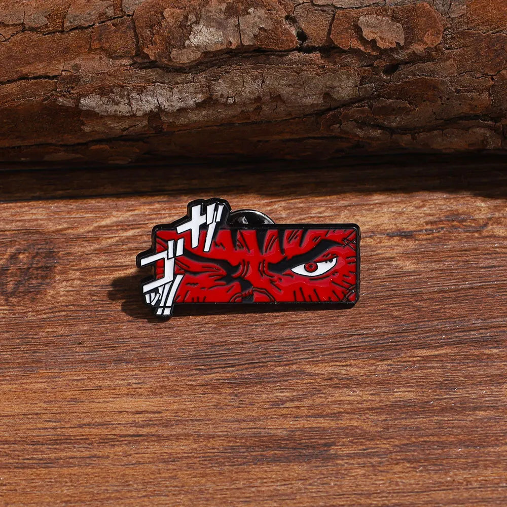 A red enamel lapel pin featuring a fierce, angry face design with white accents.