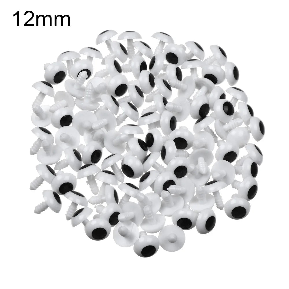 A pile of small white plastic safety eyes for crafting and stuffed animals.