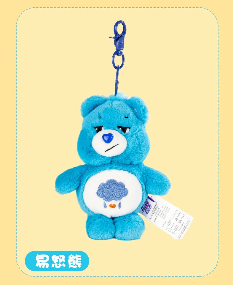 A blue Care Bears plush keychain charm with a purple hook and a white tag.