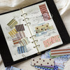 A collection of vintage washi paper sticker sheets in various grid and patterned designs for scrapbooking.