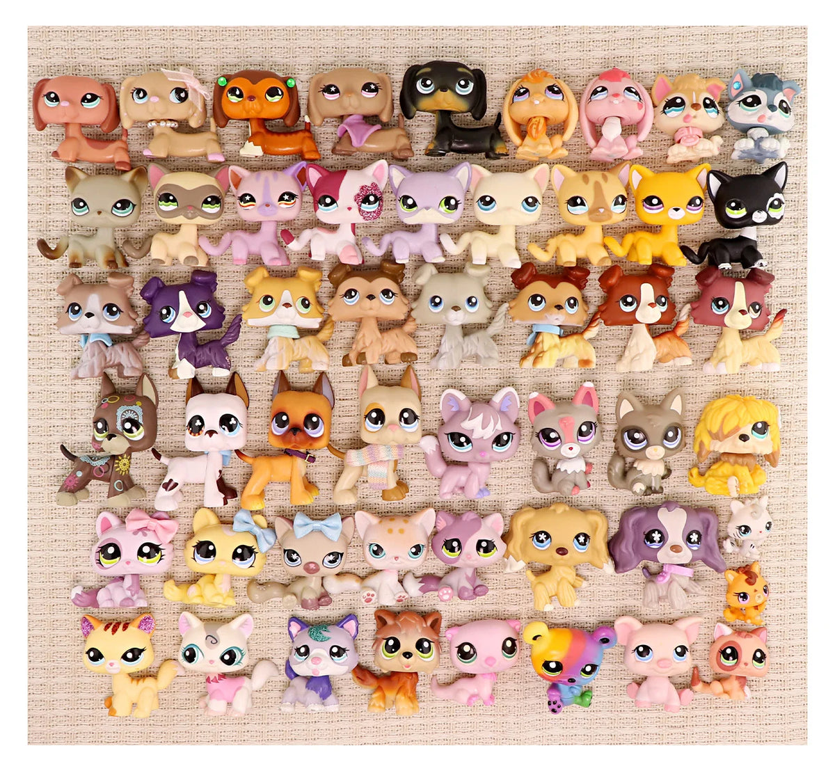 A collection of miniature pet animal figures in various colors and breeds arranged in a single row.