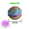 A round beige squishy toy shaped like a dumpling, with a pink spherical version shown next to it.