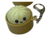A squishy dumpling shaped keychain with an LED glow inside a yellow container.