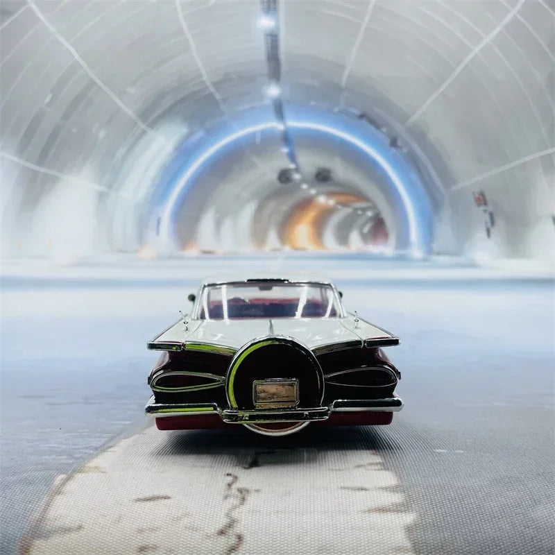 A die-cast model of a vintage 1959 Chevrolet Impala car displayed on a smooth, reflective surface.
