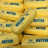 A close-up view of yellow butter sticks packaged in blue labels, showing various sizes and textures.