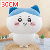 A white and blue Chiikawa plush doll with large eyes sitting on a textured surface.