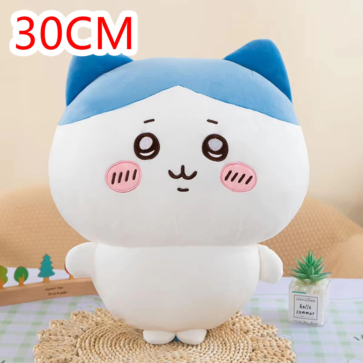 A white and blue Chiikawa plush doll with large eyes sitting on a textured surface.