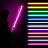 A person holds a glowing pink lightsaber against a background of horizontal colored light bars.