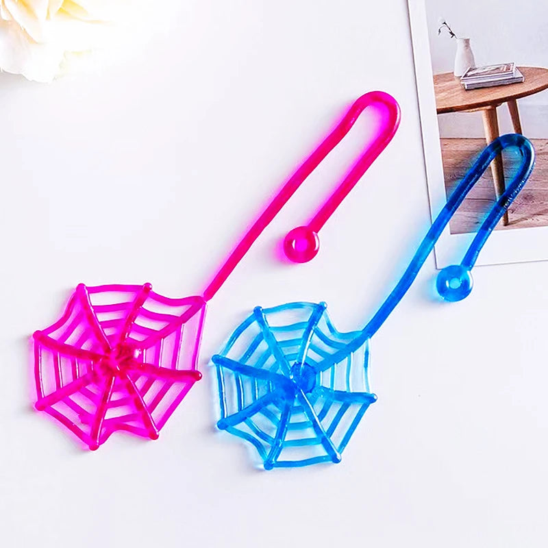 Two bright pink and blue stretchy spider web toys with handles and balls on a white surface.
