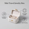 A beige mini travel jewelry box with a lid open, showing space for rings and bracelets.