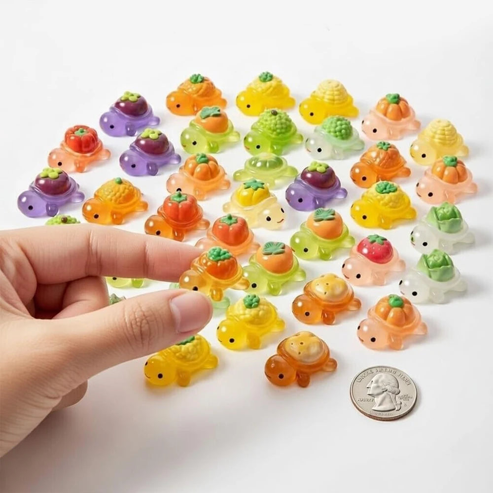 A hand holds a collection of mini glow-in-the-dark turtle resin figurines in various colors on a white background.