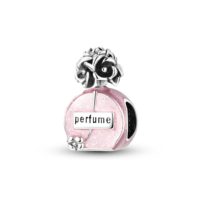 A silver heart charm bead with a pink zircon and the word perfume engraved on it.