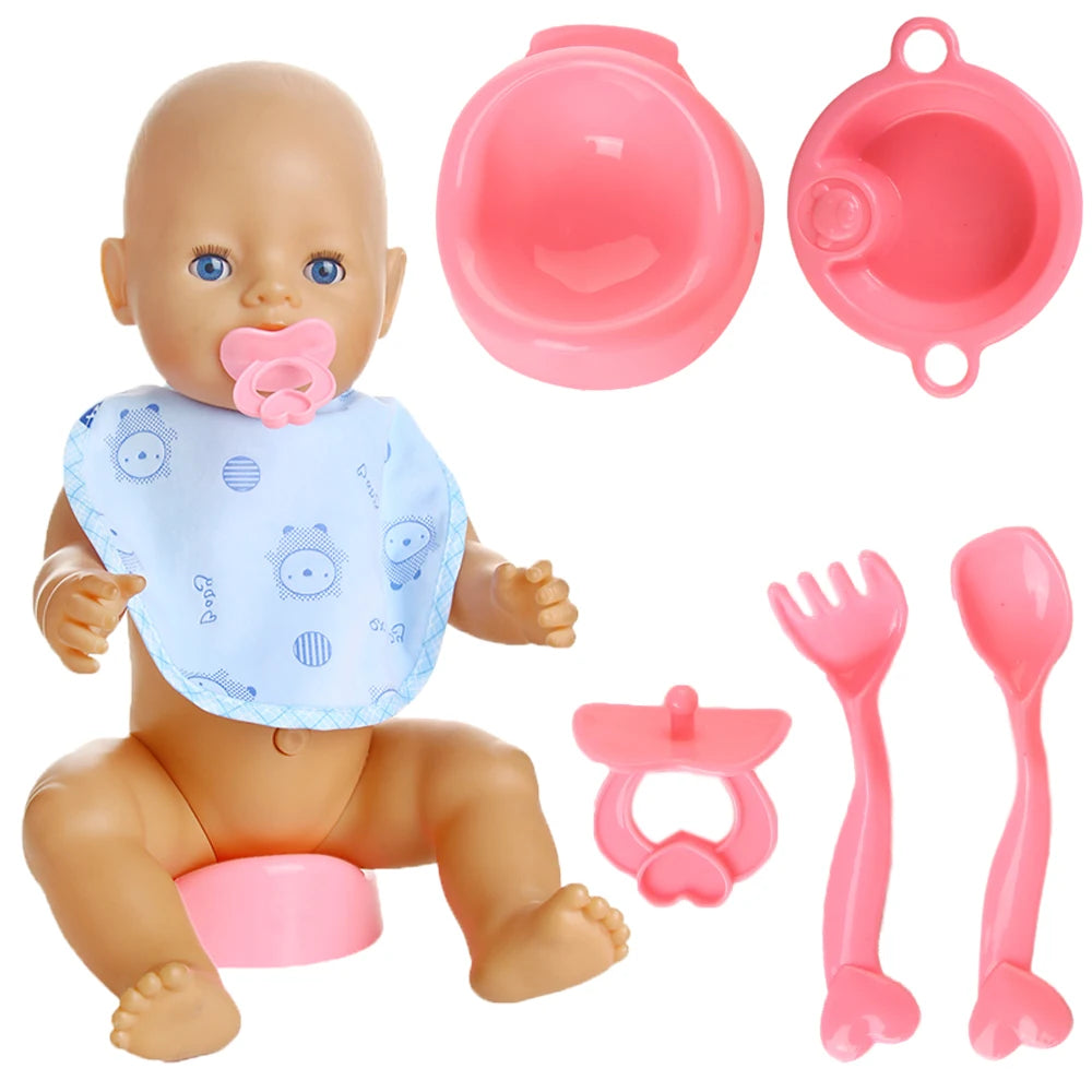 A set of pink and blue feeding accessories for a doll, including a bowl, plate, spoon, and bib.