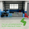 A collection of gray and blue model parts, including tools and components, displayed in front of a garage workshop background