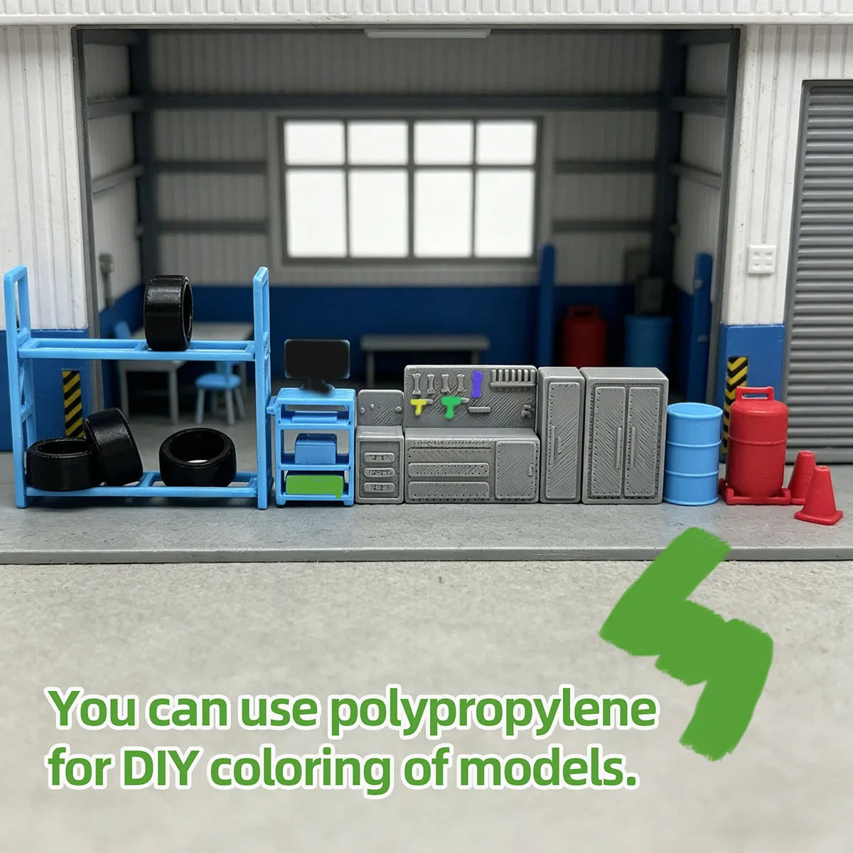 A collection of gray and blue model parts, including tools and components, displayed in front of a garage workshop background